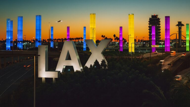 Illuminated LAX sign at Los Angeles International Airport at night – representing Encinitas to LAX Airport transfer by Richline Transportation