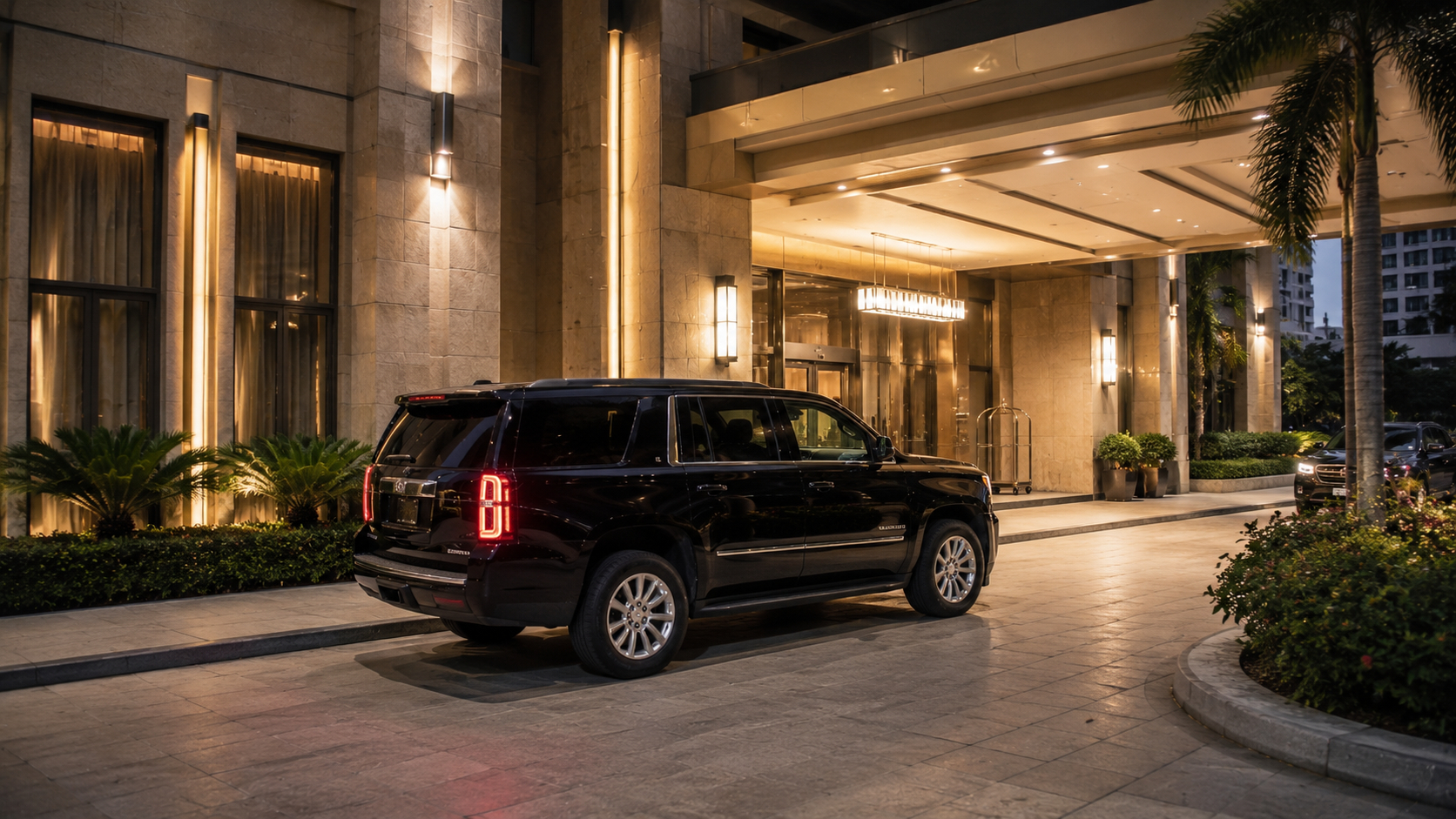 San Diego nightlife transportation with a black luxury SUV waiting outside an illuminated upscale hotel entrance